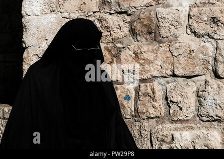 Jérusalem, Israël. 11 octobre, 2018. Une femme musulmane porte une burqa et des lunettes de soleil couvrant son corps et visage alors qu'elle marche dans la vieille ville de Jérusalem à l'intérieur de la porte d'Hérode. Banque D'Images