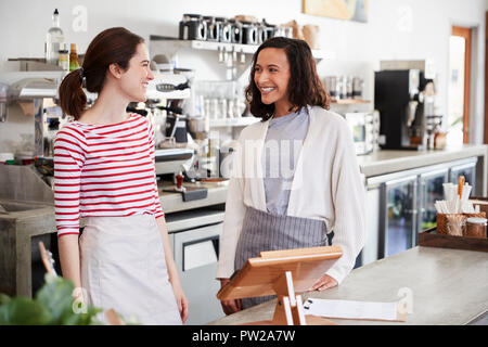 Deux femmes propriétaires de café à l'un l'autre Banque D'Images
