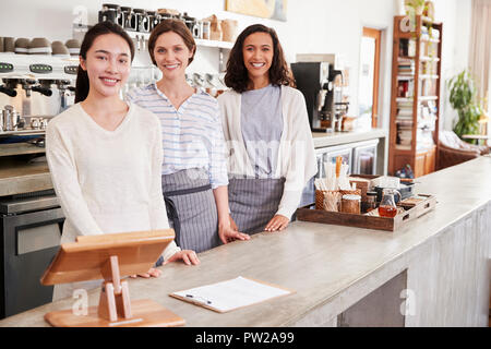 Trois femmes propriétaires de café debout derrière le comptoir Banque D'Images