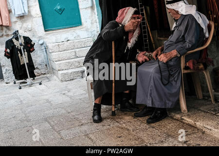 Jérusalem, Israël. 11 octobre, 2018. Personnes âgées Hommes Arabes musulmans en costume traditionnel converser l'entrée d'une boutique dans la vieille ville de Jérusalem le quartier musulman. Banque D'Images