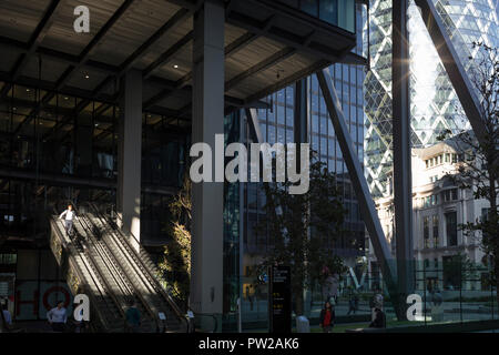 Au milieu de l'après-midi du soleil illumine les escaliers mécaniques de 1, Leadenhall et dans l'arrière-plan, le Swiss Re Building sur St Mary Axe (aka le Gherkin) dans la ville de Londres - le quartier financier de la capitale, le 10 octobre 2018, à Londres, en Angleterre. Banque D'Images