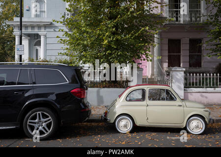 Un gros 4x4 SUV voiture garée derrière une beaucoup plus petite Fiat 500 parmi les feuilles d'automne sur Elgin Crescent à Notting Hill, le 7 octobre 2018, à Londres, en Angleterre. Banque D'Images