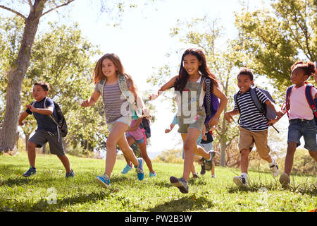 Groupe multi-ethnique des élèves courir dans le parc Banque D'Images