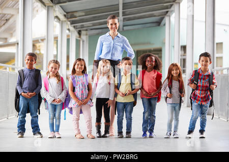 Institutrice et ses élèves en couloir d'école Banque D'Images