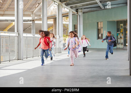 Les enfants de l'école élémentaire d'exécution en couloir d'école, side view Banque D'Images