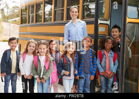 Enseignant de l'école primaire et des élèves par autobus scolaire permanent Banque D'Images