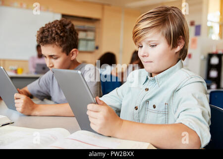 Les garçons de l'école primaire à l'aide de tablet computers in class Banque D'Images