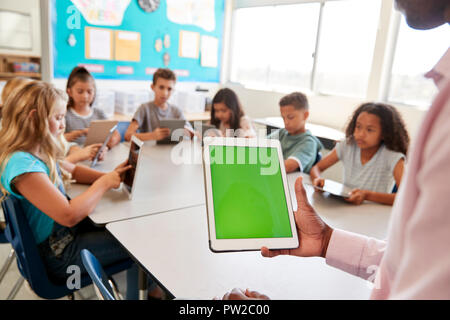 Enfants et enseignants à l'aide de tablettes à l'école élémentaire leçon Banque D'Images