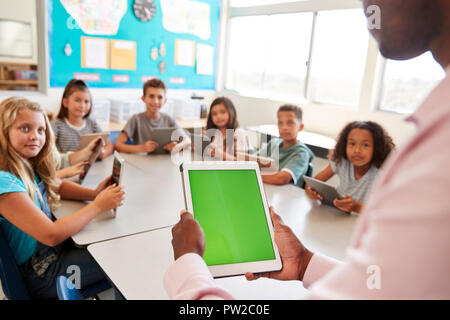 Enfants et enseignants à l'aide de tablettes à l'école élémentaire leçon Banque D'Images