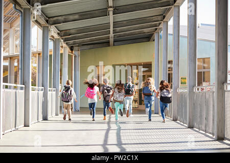 Les enfants de l'école élémentaire d'exécution en couloir d'école, vue de dos Banque D'Images