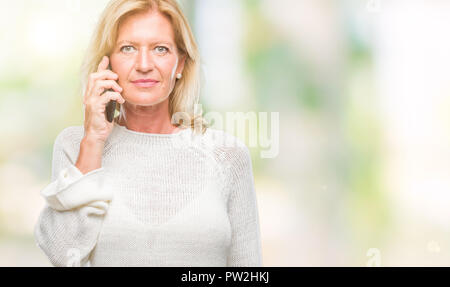 L'âge moyen blond Woman talking on smartphone Blackberry sur fond isolé avec une expression confiante face à la pensée intelligente grave