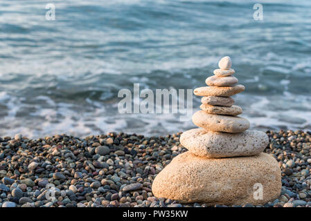 Pyramide de pierres blanches sur une plage de galets close-up concept équilibre photo Banque D'Images
