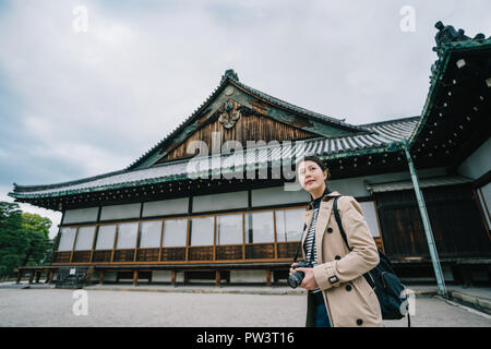 L'élégante tenant son appareil photo, visites du célèbre temple japonais. Billet à Kyoto au Japon. femme backpacker visiter le Japon seul au printemps Banque D'Images