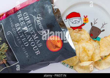 Sachet de saveur de l'arbre de Noël De Luxe Islande part salé cuit-Chips ouvert avec table des matières déversées renversé sur la plaque de Noël avec le Père Noël et Rudolf Banque D'Images