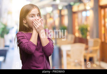 Belle jeune fille sur fond isolé choqué couvrant la bouche avec les mains pour l'erreur. Concept Secret. Banque D'Images