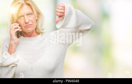 L'âge moyen blond Woman talking on smartphone Blackberry sur fond isolé avec face en colère, signe négatif montrant non avec Thumbs down, rejet conc