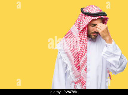 Beau jeune homme portant un keffieh sur fond isolé fatigué se frottant le nez et les yeux sentant la fatigue et les céphalées. Le stress et la frustration concept. Banque D'Images