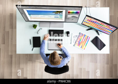 Portrait de femme rédactrice à l'aide de tablette graphique en travaillant sur Computer in Office Banque D'Images