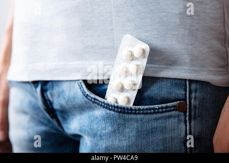 Close-up of White Pills In Blue Jeans Pocket Banque D'Images