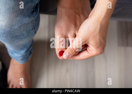 Close-up of a Woman's Hand Holding orteil douloureux Banque D'Images