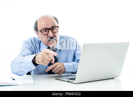 1960 senior businessman patron furieux hurlant et gesticulant contrarié et mad sitting on desk dans la gestion et problèmes de stress au travail isolé sur bac blanc Banque D'Images