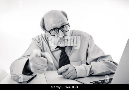 1960 senior businessman patron furieux hurlant et gesticulant contrarié et mad sitting on desk dans la gestion et problèmes de stress au travail isolé sur bac blanc Banque D'Images