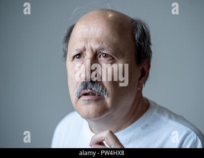 Close up portrait of senior vieil homme pensant et looking pensive avec visage réfléchie dans les émotions humaines et l'expression faciale concept isolé sur gray Banque D'Images