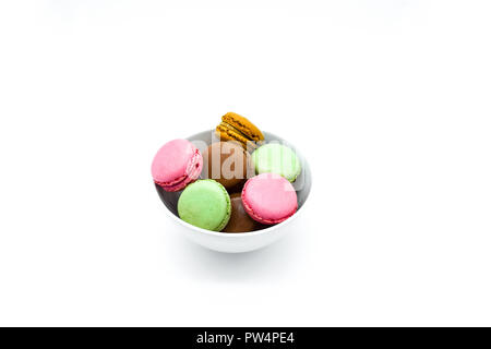 Dans un bol, doux macarons macarons colorés sur fond blanc Banque D'Images