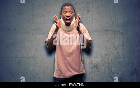 Homme noir africain blessés wearing neck brace stressant en gardant les mains sur la tête, terrifié, criant en panique Banque D'Images