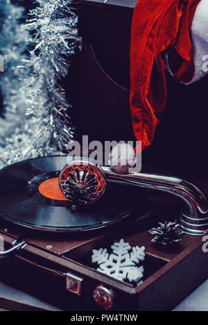 Image de Noël. La lecture d'un gramophone record. Avec Gramophone vinyl record sur fond de décorations de Noël, Noël hat. Banque D'Images