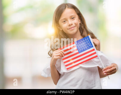 Brunette woman holding drapeau de États-Unis d'Amérique avec un visage heureux et souriant debout avec un sourire confiant montrant les dents Banque D'Images