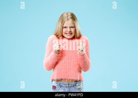 Angry girl standing on trendy studio bleu arrière-plan. Moitié femelle portrait en pied. Les émotions humaines, l'expression faciale concept. Banque D'Images