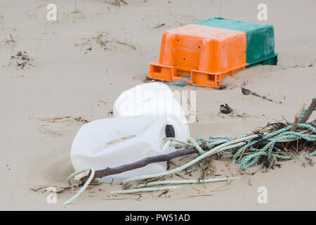 Le plastique déchets rejetés sur une plage et la partie enterrée dans le sable d'un exemple des nombreux morceaux d'ordures dans les océans du monde entier Banque D'Images