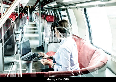 Business Woman working on Laptop et Smartphone dans un train de première classe, en Suisse. Banque D'Images