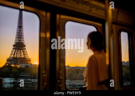 Jeune femme profitant de vues sur la Tour Eiffel depuis le métro train durant le lever du soleil à Paris. L'accent sur l'image l'arrière-plan Banque D'Images