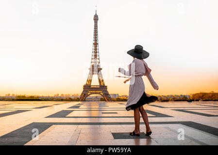 Femme vêtue de manteau et hat marche sur la célèbre place avec très belle vue sur la Tour Eiffel tôt le matin à Paris Banque D'Images