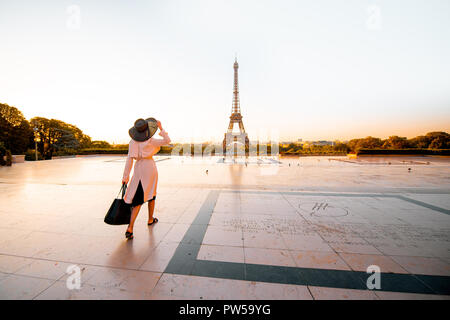 Femme vêtue de manteau et hat marche sur la célèbre place avec très belle vue sur la Tour Eiffel tôt le matin à Paris Banque D'Images