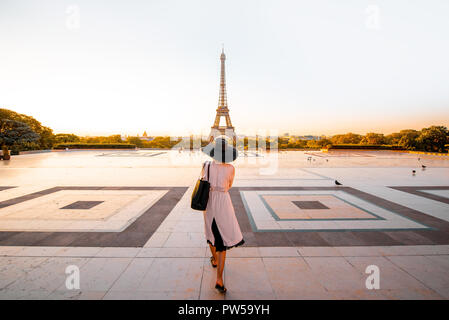 Femme vêtue de manteau et hat marche sur la célèbre place avec très belle vue sur la Tour Eiffel tôt le matin à Paris Banque D'Images