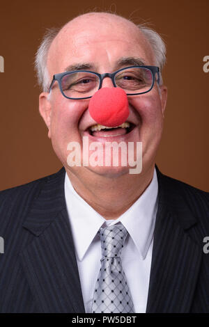 L'embonpoint senior businessman wearing red clown nose Banque D'Images