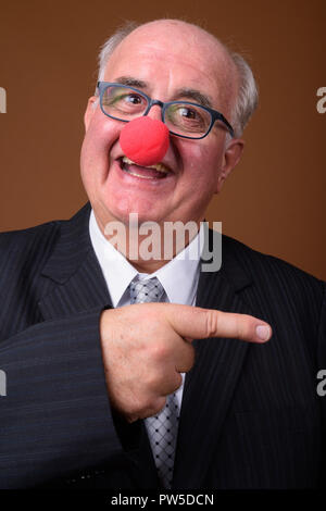 L'embonpoint senior businessman wearing red clown nose Banque D'Images