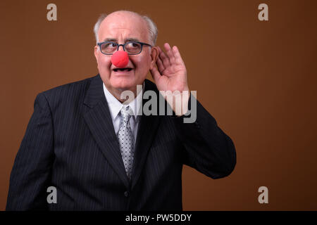 L'embonpoint senior businessman wearing red clown nose Banque D'Images