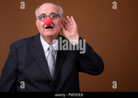 L'embonpoint senior businessman wearing red clown nose Banque D'Images