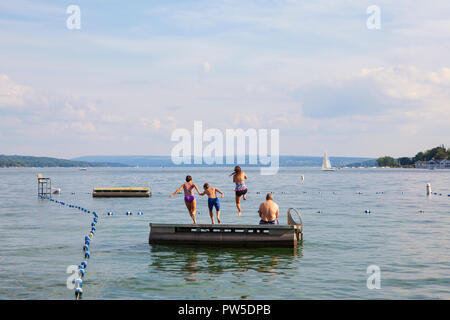 Une famille saute dans Skaneateles Lake, Skaneateles, New York, USA, 14 juin, 2013. Banque D'Images