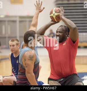 Vétéran du Corps des marines Matthieu Grashen tente de bloquer une passe par le vétéran de l'armée que les Etats-Unis Pone Anthony équipe de basket-ball en fauteuil roulant des trains pour l'Invictus Jeux à l'Université Hofstra, à New York, le 19 septembre 2017. À gauche est le capitaine de l'Armée de l'Air Cal Gentry. L'Invictus Games, établi par le prince Harry en 2014, rassemble des blessés et les anciens combattants blessés de 17 nations pour 12 événements sportifs adaptative, y compris l'athlétisme, le basket-ball en fauteuil roulant, rugby en fauteuil roulant, la natation, le volleyball assis, et nouveaux pour le jeux 2017, golf. Banque D'Images