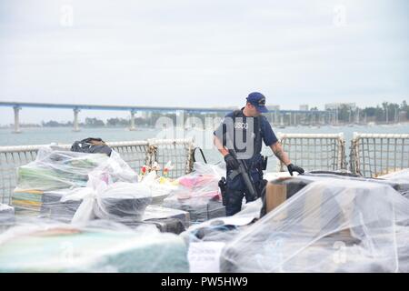 Maître de 2e classe Alexander Davis, maîtres d'officier de pont, garde-côte de Stratton, inspecte les ballots de cocaïne et d'héroïne au cours de la Stratton's drug offload, San Diego, le 20 septembre 2017. L'équipage de la garde-côte de Stratton débarqué 50 550 livres de cocaïne et d'héroïne d'une valeur de 679 millions $ le plus. Banque D'Images