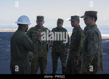 WHITE BEACH (sept. 20, 2017), l'Adjudant-chef Daryle 3 Howard, gauche, lutter contre l'agent de la cargaison des navires d'assaut amphibie USS Bonhomme Richard (DG 6), explique les procédures et les processus marins embarquent sur le pont d'envol du navire amphibie aux membres de la Brigade d'intervention rapide (ARDB) pré-mise en service unité, qui deviendra le bras amphibie de la masse des forces d'autodéfense du Japon de l'Armée de l'Ouest. L'échange a eu lieu dans le cadre des efforts en cours entre les États-Unis et le Japon à augmenter la capacité amphibie combinée à l'appui de l'alliance de longue date des deux pays. Bonhomme Richard, fl Banque D'Images