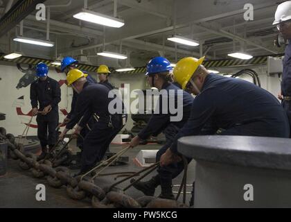 SAN DIEGO (sept. 21, 2017) Les marins affectés au navire d'assaut amphibie USS Makin Island (DG 8) déplacer l'ancre tribord au cours de la chaîne d'une chaîne à décharger dans le gaillard. Makin Island est actuellement en cale sèche à General Dynamics et de l'Acier National Shipbuilding Company (NASSCO) pour un dépôt d'entretien au niveau de disponibilité. Banque D'Images