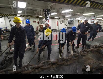 SAN DIEGO (sept. 21, 2017) Les marins affectés au navire d'assaut amphibie USS Makin Island (DG 8) déplacer l'ancre tribord au cours de la chaîne d'une chaîne à décharger dans le gaillard. Makin Island est actuellement en cale sèche à General Dynamics et de l'Acier National Shipbuilding Company (NASSCO) pour un dépôt d'entretien au niveau de disponibilité. Banque D'Images