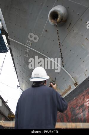 SAN DIEGO (sept. 21, 2017) Premier maître de Manœuvre principal Claus Moser communique avec les marins dans le gaillard d'avant du navire d'assaut amphibie USS Makin Island (DG 8) tout en réduisant la charge des chaînes d'ancre tribord. Makin Island est actuellement en cale sèche à General Dynamics et de l'Acier National Shipbuilding Company (NASSCO) pour un dépôt d'entretien au niveau de disponibilité. Banque D'Images