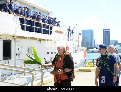 Leighton Tseu, Kane O Ke Kai, donne une bénédiction hawaïenne avec Lieutenant Kenneth Franklin, commandant de la garde-côte de Oliver Berry (WPC 1124) à base de la Garde côtière canadienne, Honolulu, le 22 septembre 2017. L'Oliver Berry arrivés à Honolulu de devenir la première des trois 154 pieds de coupeurs de réponse rapide en poste à Hawaï. Banque D'Images